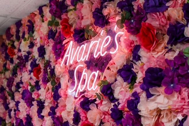 Neon sign on floral wall at spa